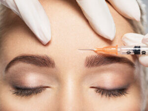 Womanr recieving botox injection in forehead