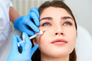 Brunette having dermal filler under eyes